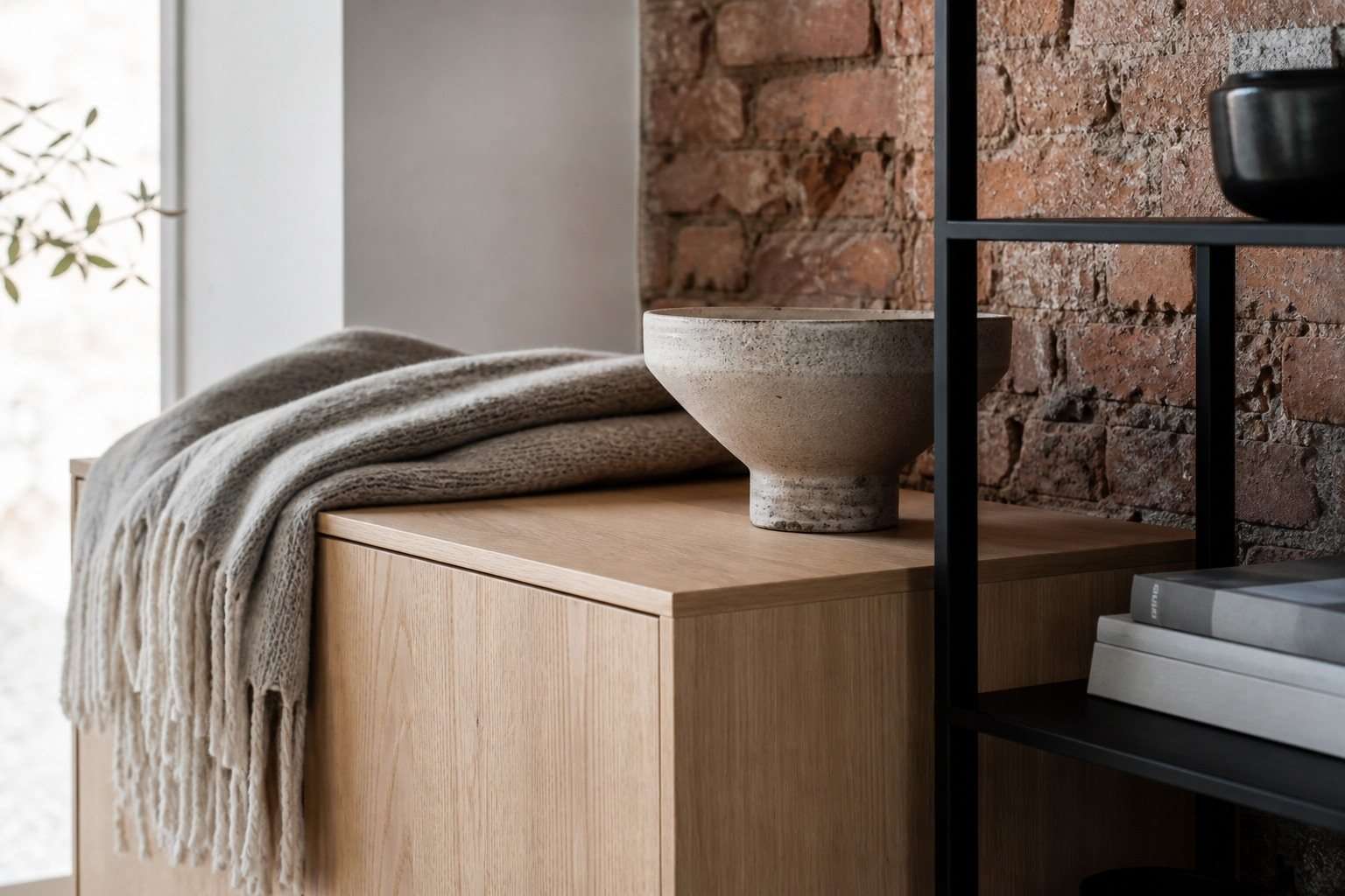 Detalle de lana, roble, ladrillo envejecido y acero mate en un interior nórdico industrial